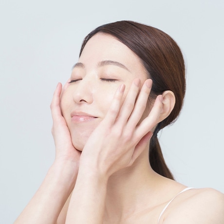窓辺でストレッチをする穏やかな表情の女性